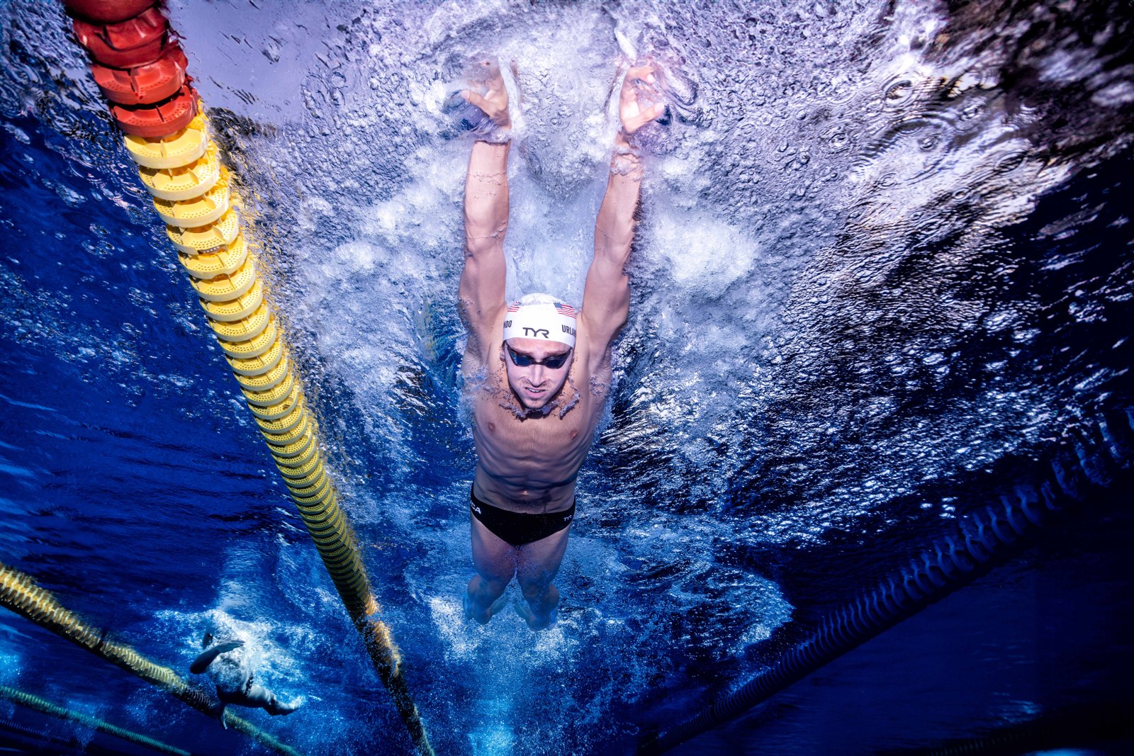 Luca Urlando streamlines underwater beside a yellow lane rope.