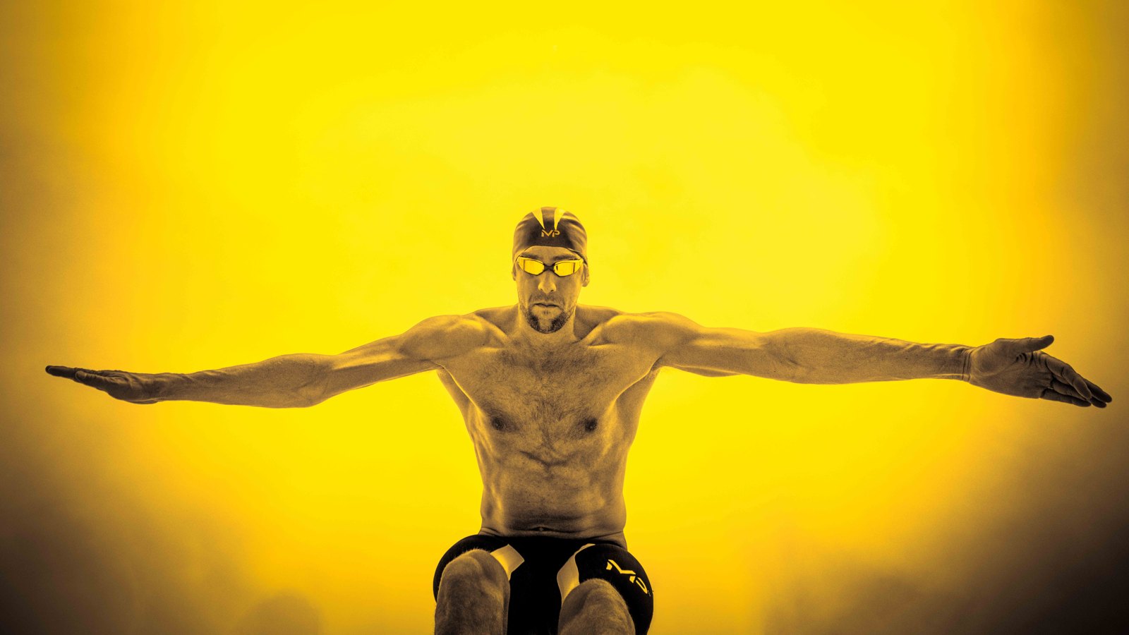 Michael Phelps extends his arms across a vivid yellow background.